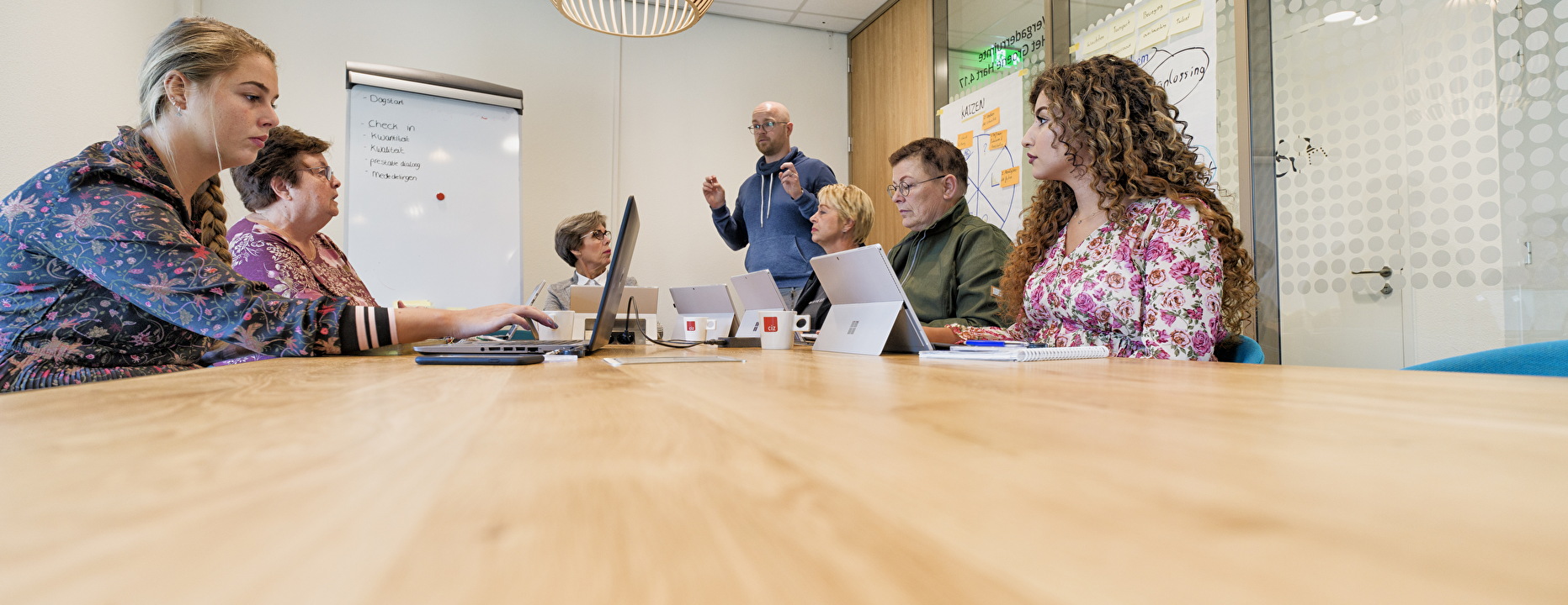 Meerdere mensen aan tafel tijdens overleg