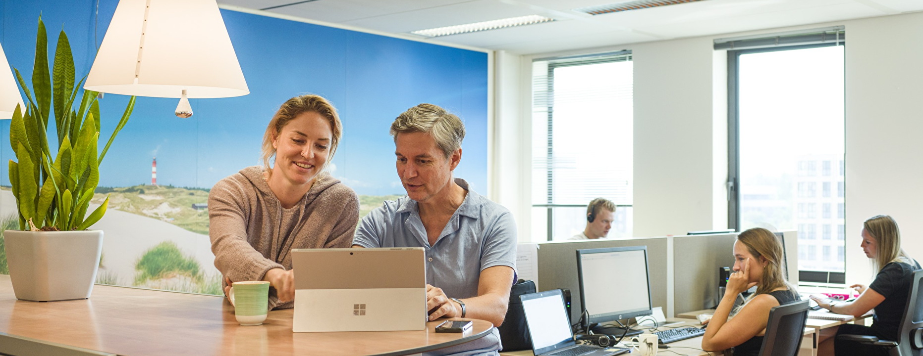 Meerdere mensen achter een computer op kantoor